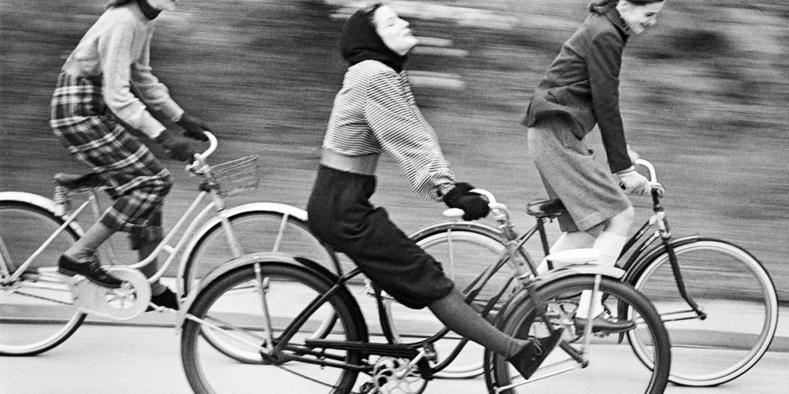 black and white photo of women riding bikes
