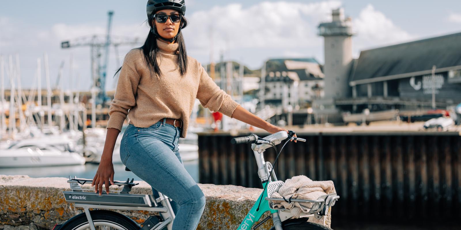 woman riding a Beryl e-bike by a harbour