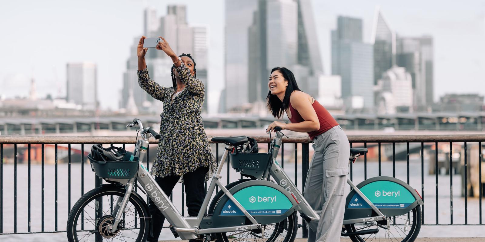 Two riders using Beryl's new BBE2 e-bike with a London cityscape in the background