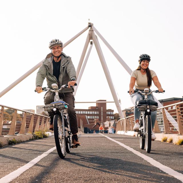 Two riders going over a bridge on Beryl bikes in Norwich