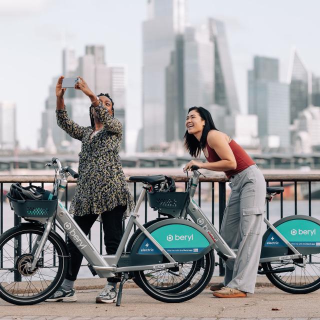 Two riders using Beryl's new BBE2 e-bike with a London cityscape in the background