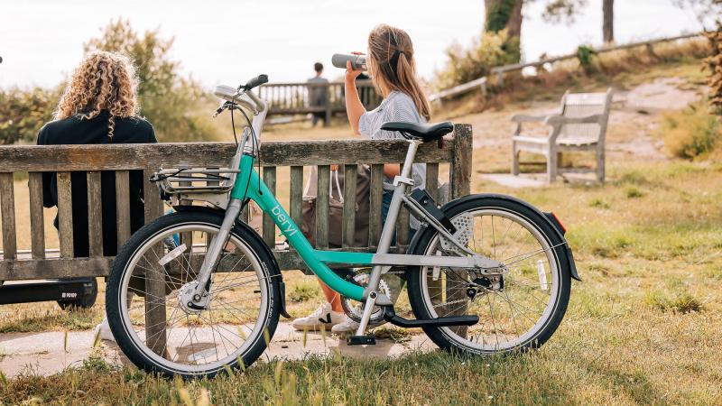 Women sitting on bench with Beryl bike in Dorset